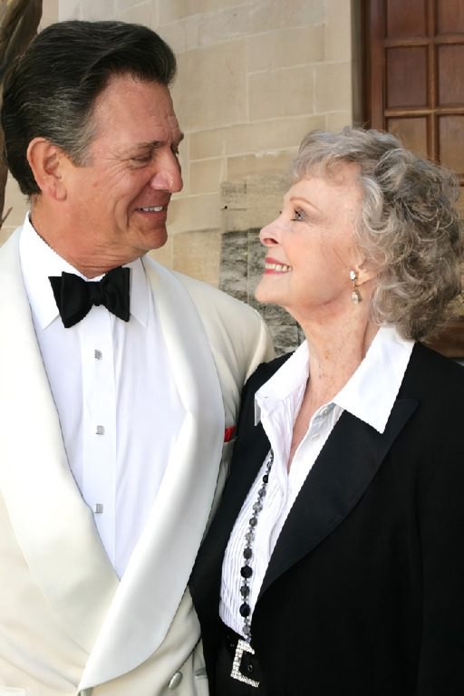 A man and woman in formal wear standing next to each other.