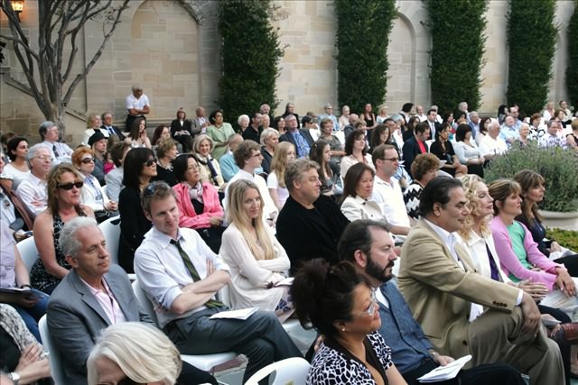 A crowd of people sitting in chairs at an event.