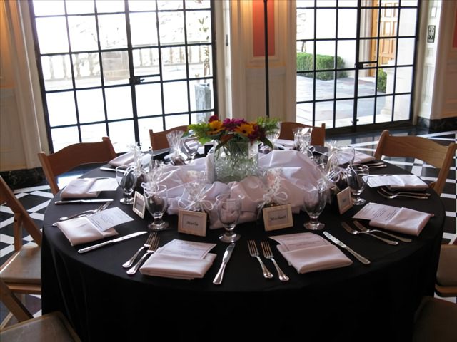 A table with many place settings and flowers on it
