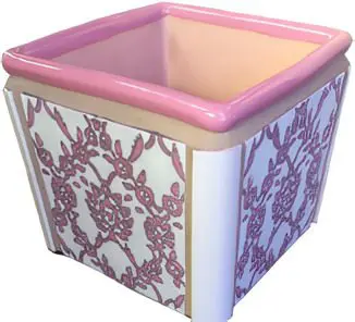 A pink and white planter with flowers on it.