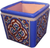 A blue and white square planter with a pattern.