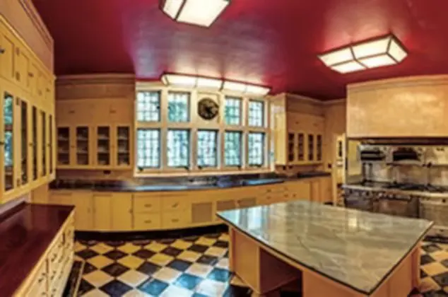 A kitchen with a large counter and checkered floor.
