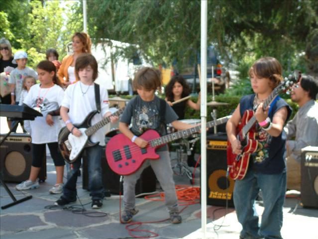A group of kids playing guitar on the street
