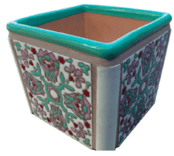 A square planter with a floral design on it.