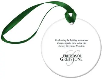 A white ornament with green ribbon around it.