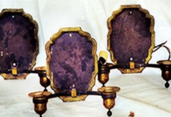 A trio of purple and gold wall sconces.