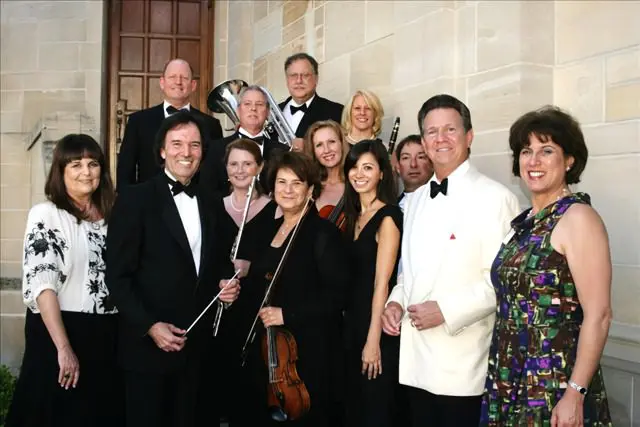 A group of people in formal attire posing for a picture.